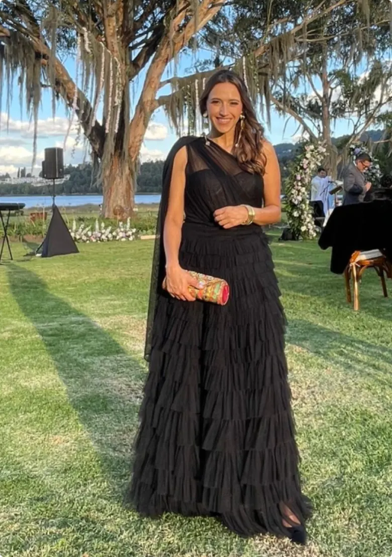 Invitada en vestido negro de tul en un matrimonio al aire libre